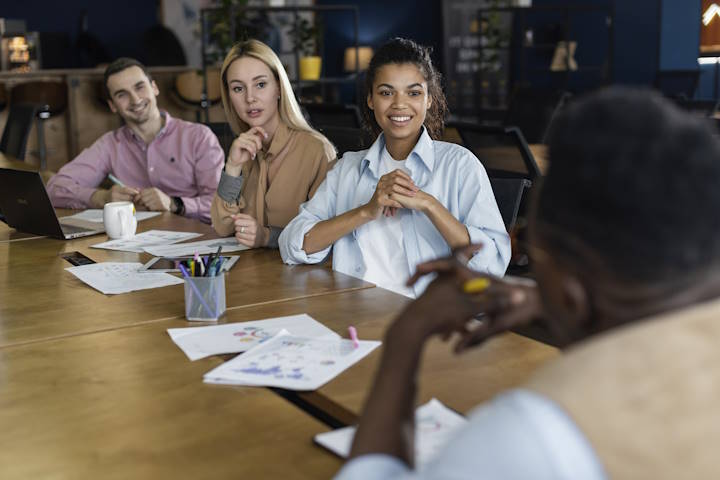 Team members participating in a workplace meeting about employment equity compliance and workforce planning in an office setting.